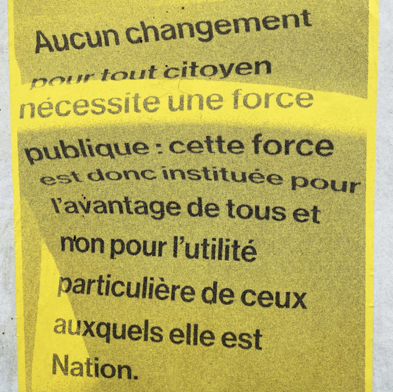 affiche jaune sur mur blanc dans Gentilly, sur l'affiche est écrit : Aucun changement pour tout citoyen nécessite une force publique : cette force est donc instituée pour l’avantage de tous et non pour l’utilité particulière de ceux auxquels elle est Nation.
